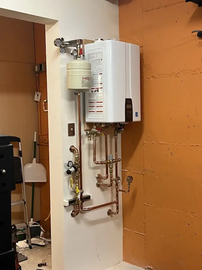 Plumbing technician inspecting water heater connections in Halawa